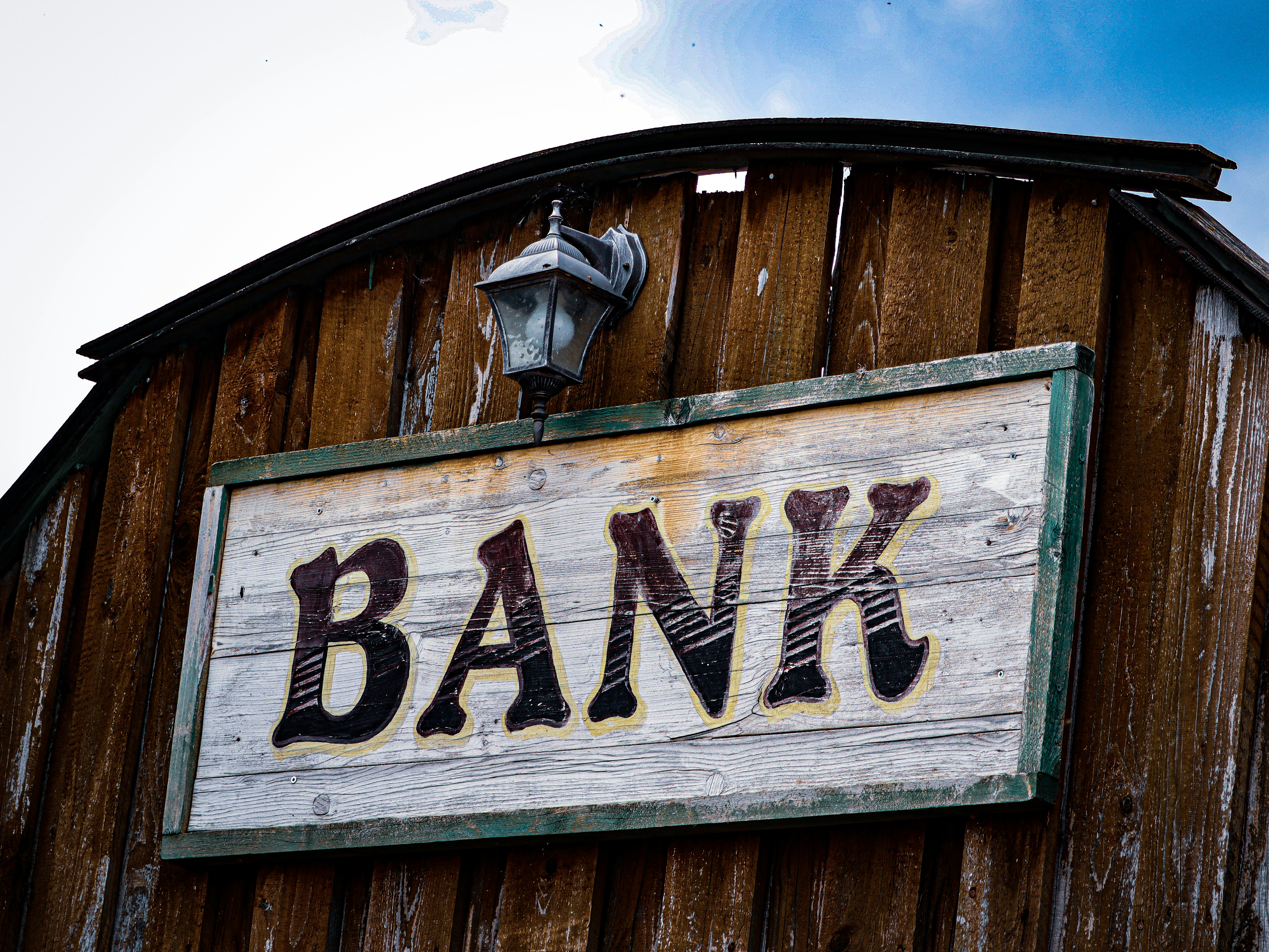 a bank sign on the side of a wooden building